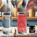 Hand stirring red color-changing brew glitter into a glass of water, next to a clear water glass and glitter jar.