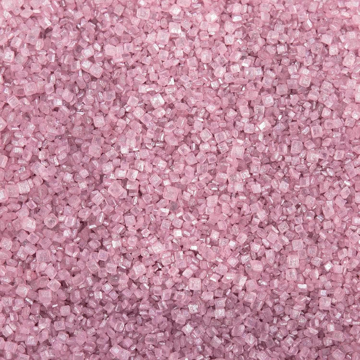 Close-up of sparkling rose gold pearl cocktail rimming sugar crystals.