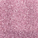 Close-up of sparkling rose gold pearl cocktail rimming sugar crystals.