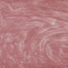 Swirling rose gold edible glitter particles creating a shimmering, metallic texture in a liquid drink.
