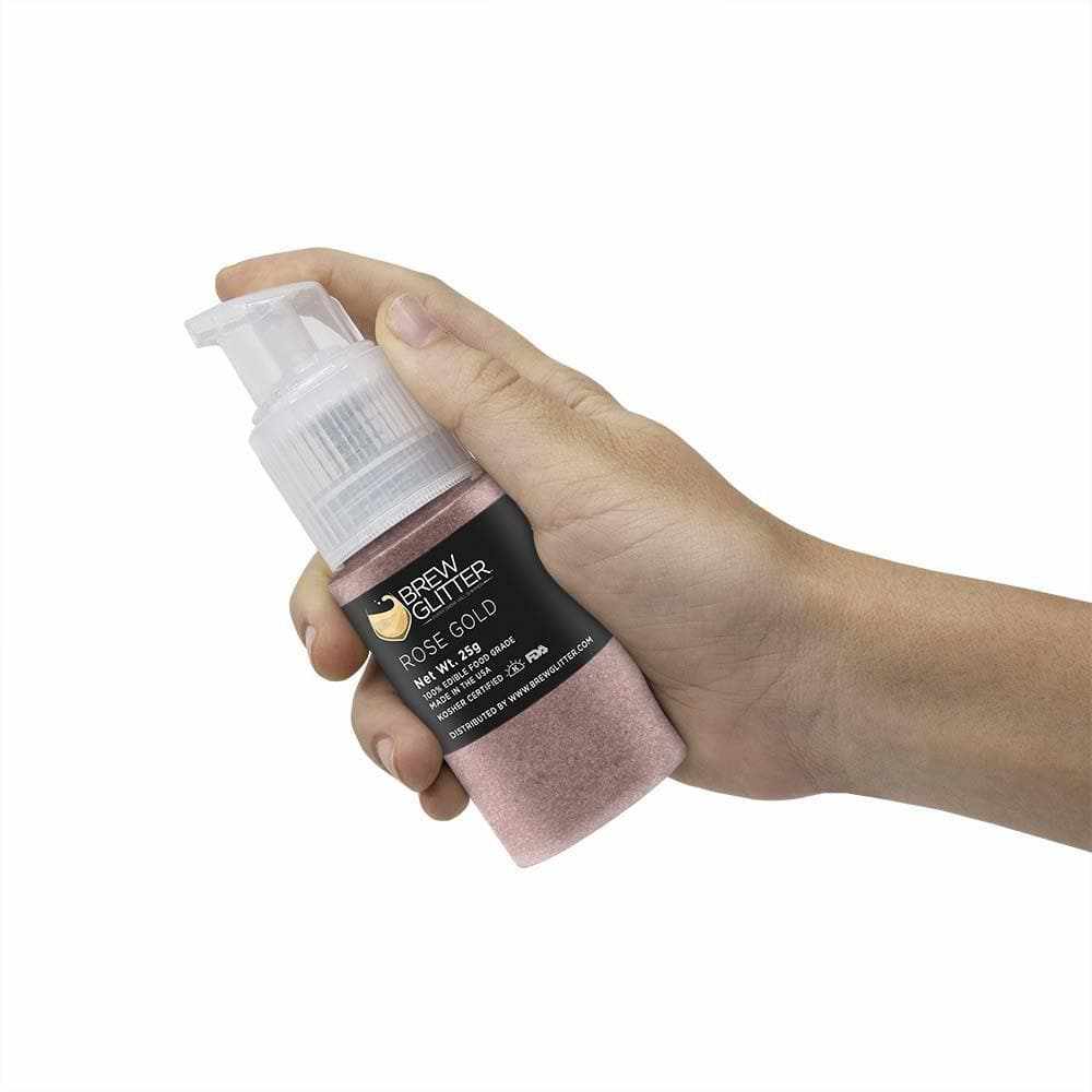 Hand holding a 25g Brew Glitter® Rose Gold edible glitter spray pump for drinks.