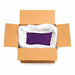 Open cardboard box with a large white bag filled with royal purple ultrafine metallic craft glitter.