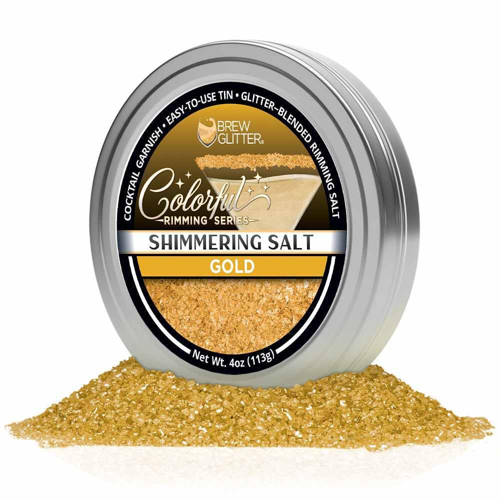 4oz tin of shimmering gold cocktail rimming salt with a black label, sitting in a pile of sparkling gold salt crystals.