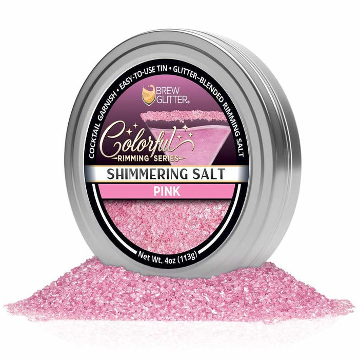 Shimmering pink cocktail rimming salt in a 4oz silver tin with a branded label and a pile of sparkling pink salt crystals.