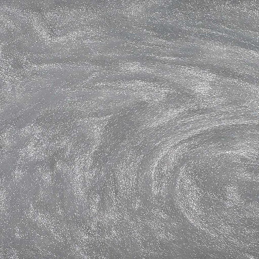 Swirling silver edible glitter dust creating a shimmering, metallic texture for cocktails and beverages.