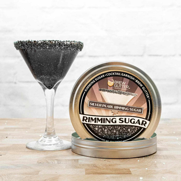 Silver Pearl Cocktail Rimming Sugar in a tin, next to a martini glass with a black sugar rim.