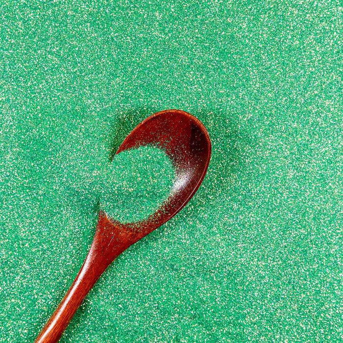 Soft Shamrock green iridescent craft glitter with a wooden spoon.