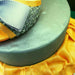 Spruce Green Luster Dust on a silver cake with purple glitter and gold ribbon accents.