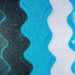 Teal blue, black, and white ultrafine iridescent craft glitter arranged in wavy stripes.