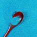 Teal blue ultrafine iridescent craft glitter with a wooden spoon holding some.
