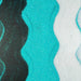 Wavy lines of turquoise ultrafine iridescent craft glitter, black glitter, and white glitter.
