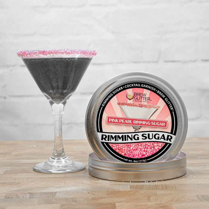 sugar rimmed dark glitter drink next to pink glitter sugar tin