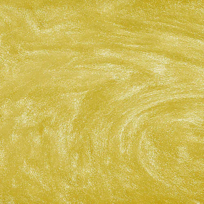Swirling yellow edible glitter particles creating a shimmering, metallic gold texture in a liquid beverage.