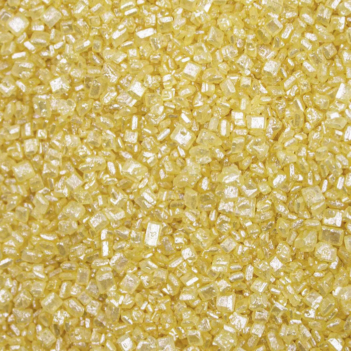 Close-up texture of sparkling yellow pearl cocktail rimming sugar with coarse, crystalline granules.