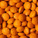 Close-up of vibrant orange, edible basketball-shaped sprinkles with embossed details.