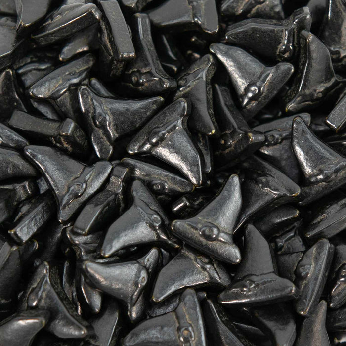 Pile of shiny black witch hat shaped edible sprinkles.