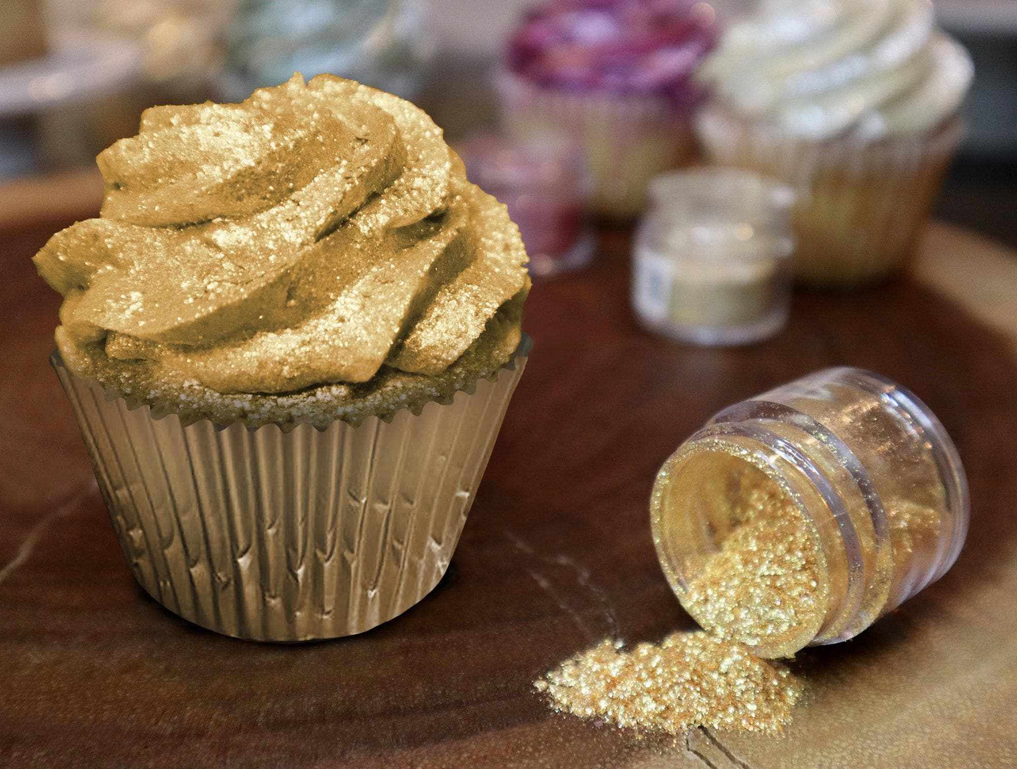 Cupcake cover in Gold Edible Glitter, and a Jar Spilled with Golden Edible Glitter to the Right | bakell.com