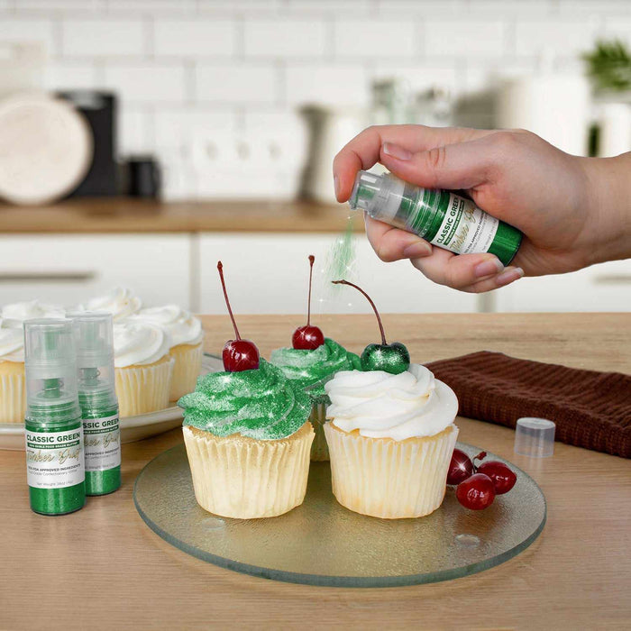 Three cupcakes being sprayed by a Classic Green colored Edible Glitter 4 gram pump. | bakell.com