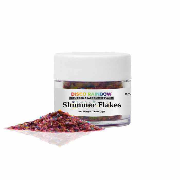 Front view of a 4 gram jar of Disco Rainbow Edible Shimmer Flakes, with some free flakes placed in front of the jar | bakell.com
