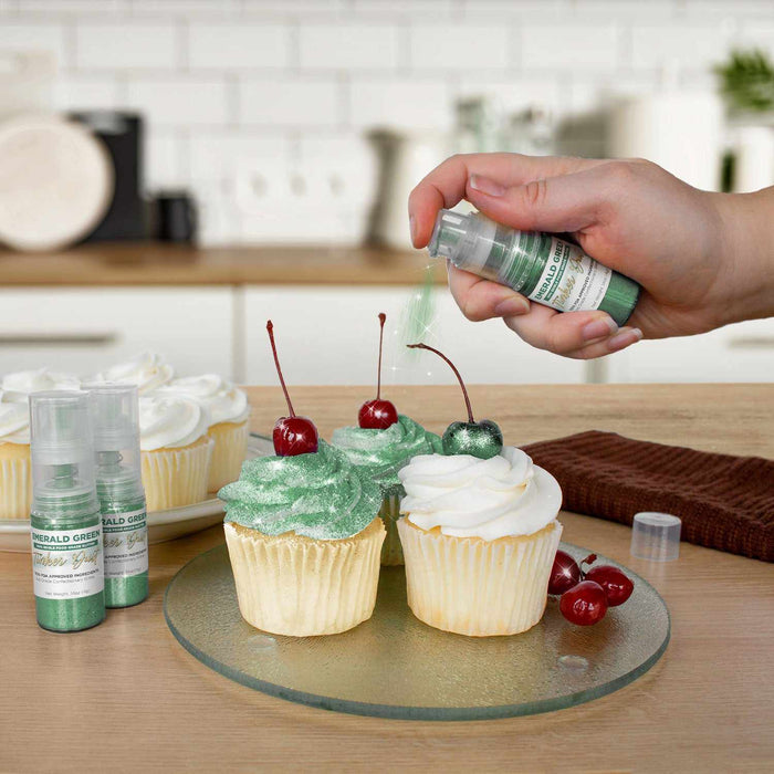 Three cupcakes being sprayed by a Emerald Green color Edible Glitter 4 gram pump. | bakell.com