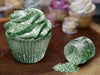 Green cupcake with edible Tinker Dust glitter, next to an open jar spilling green glitter.