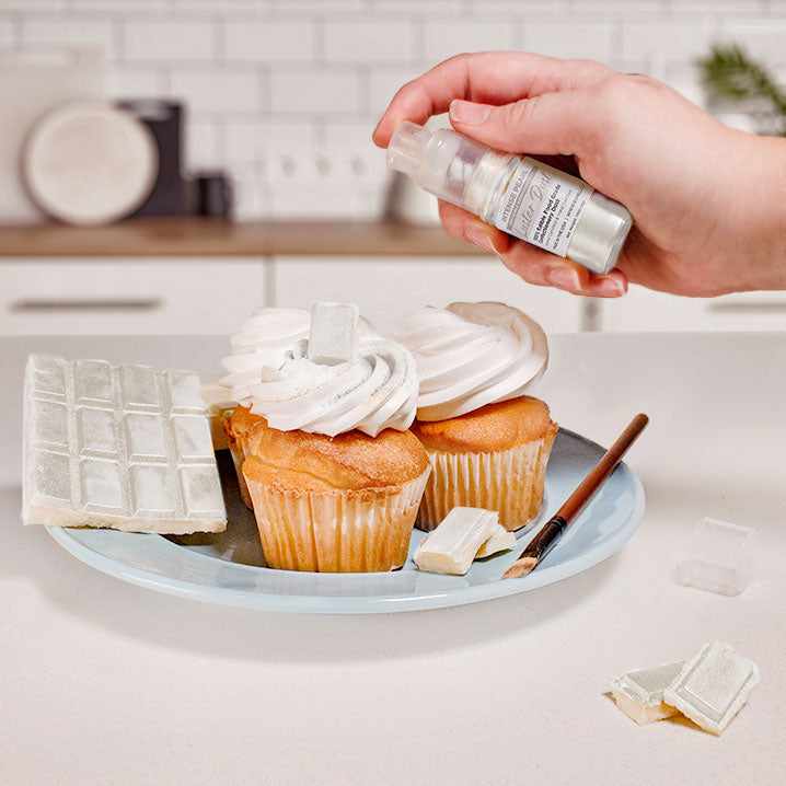 Three cupcakes and a wafer being sprayed by a White color Luster Dust 4 gram pump. | bakell.com