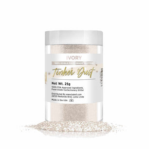 Ivory Tinker Dust edible glitter in a clear jar with a white lid, spilling onto a white surface.