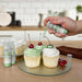 Three cupcakes being sprayed by a Leaf Green  color Edible Glitter 4 gram pump. | bakell.com