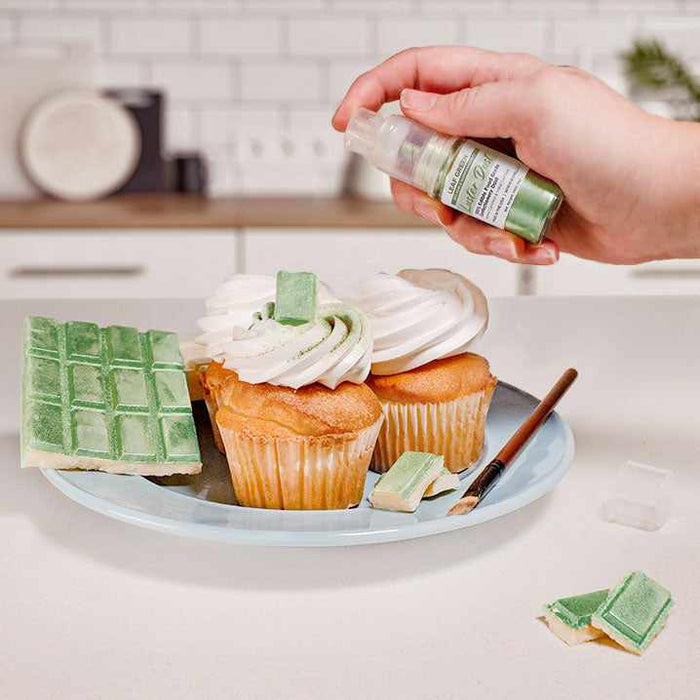 Three cupcakes and a wafer being sprayed by a Green color Luster Dust 4 gram pump. | bakell.com