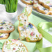 Leaf green luster dust on a white bunny cookie with floral designs and gold speckles.