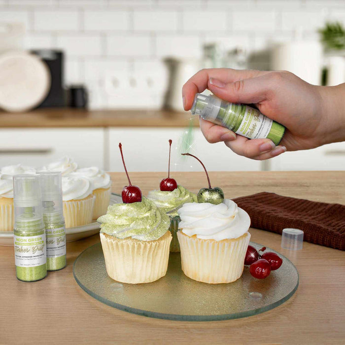 Three cupcakes being sprayed by a Neon Green color Edible Glitter 4 gram pump. | bakell.com