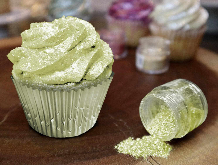 Neon green Tinker Dust edible glitter sprinkled on a cupcake next to an open jar.
