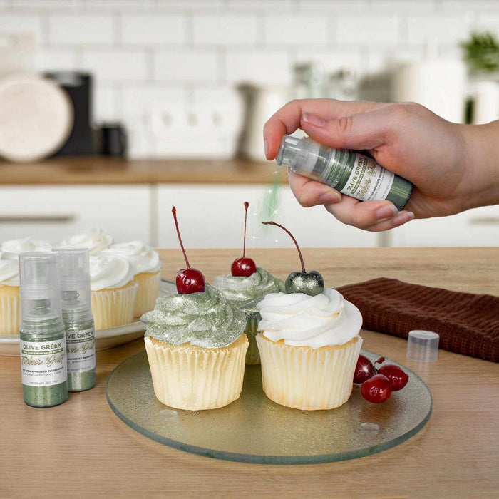 Three cupcakes being sprayed by an Olive Green color Edible Glitter 4 gram pump. | bakell.com