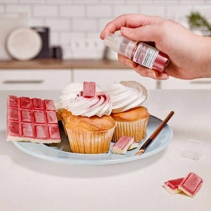 Three cupcakes and a wafer being sprayed by a Red color Luster Dust 4 gram pump. | bakell.com