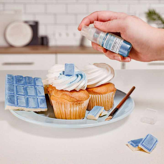 Three cupcakes and a wafer being sprayed by a Blue color Luster Dust 4 gram pump. | bakell.com