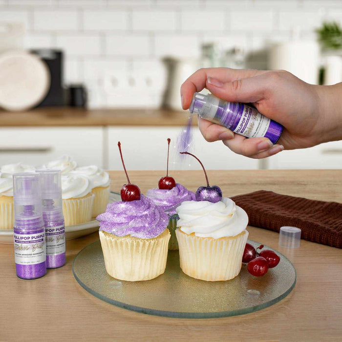 Three cupcakes being sprayed by a Purple color Edible Glitter 4 gram pump. | bakell.com