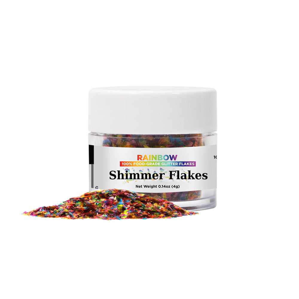 Front view of a 4 gram jar of Rainbow Edible Shimmer Flakes, with some free flakes placed in front of the jar | bakell.com