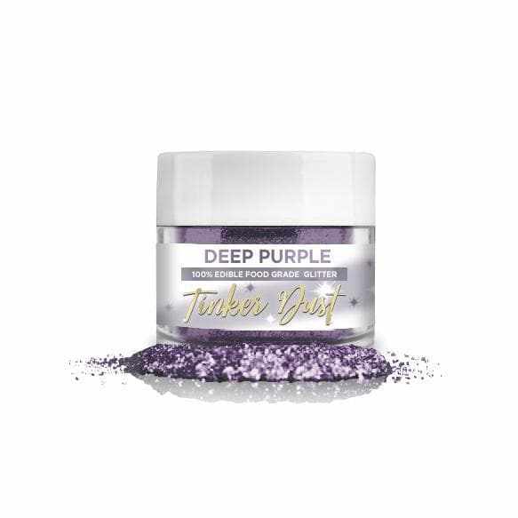 Deep Purple Tinker Dust edible glitter in a clear jar with white lid, spilled on a white surface.
