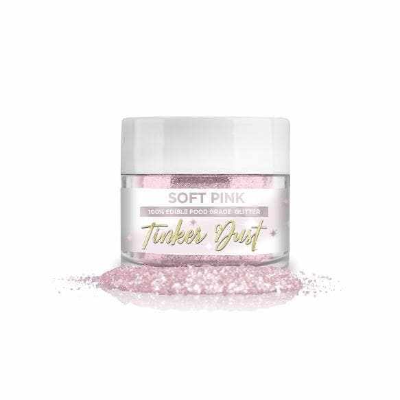 Soft Pink Tinker Dust, 100% edible food grade glitter in a clear jar with white lid, spilled on a white surface.