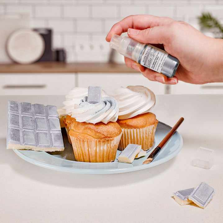 Three cupcakes and a wafer being sprayed by a Silver color Luster Dust 4 gram pump. | bakell.com