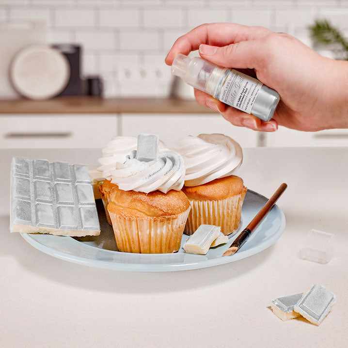 Three cupcakes and a wafer being sprayed by a White color Luster Dust 4 gram pump. | bakell.com