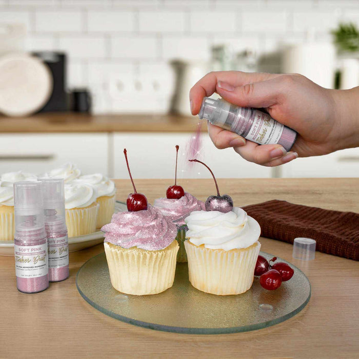 Three cupcakes being sprayed by a Soft Pink color Edible Glitter 4 gram pump. | bakell.com