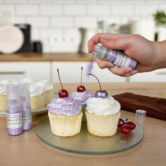 Three cupcakes being sprayed by a Soft Purple color Edible Glitter 4 gram pump. | bakell.com