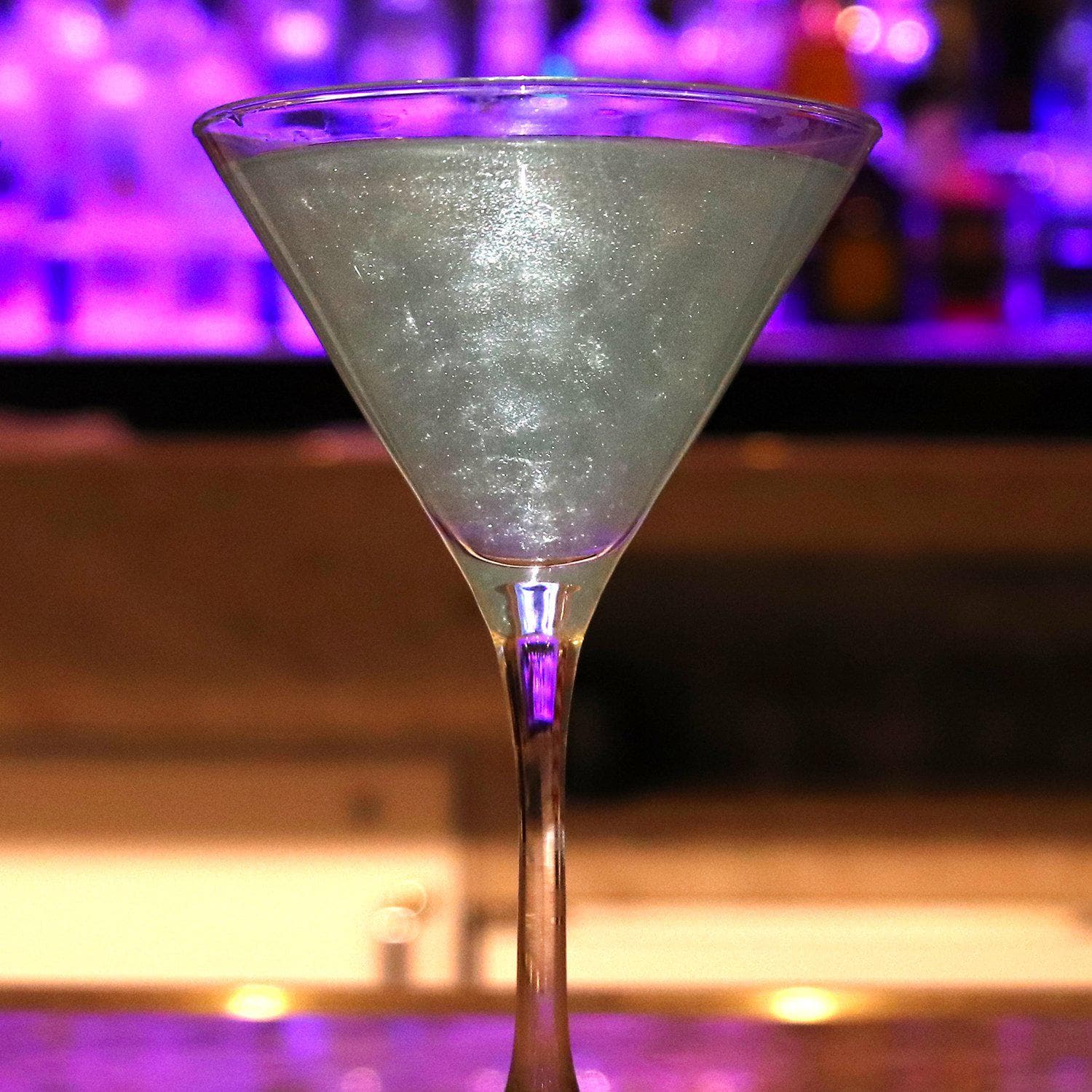 Clear shimmering edible glitter in a martini glass, perfect for summer cocktails.