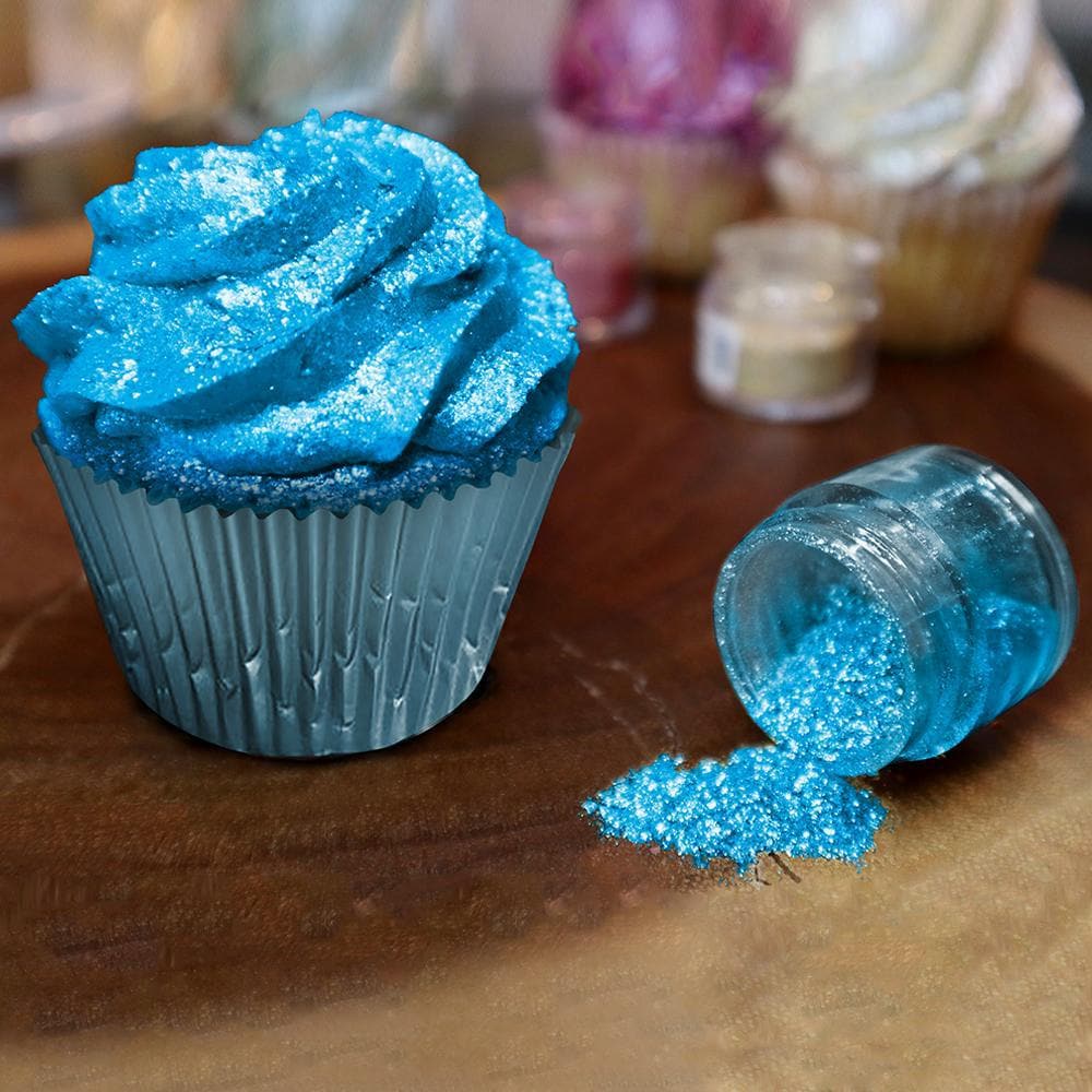Blue cupcake with edible glitter and an open jar of turquoise Tinker Dust.