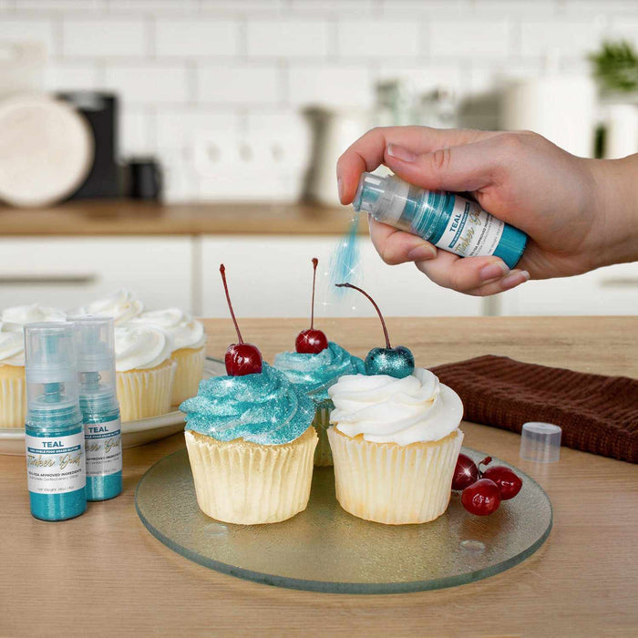 Three cupcakes being sprayed by a Teal color Edible Glitter 4 gram pump. | bakell.com