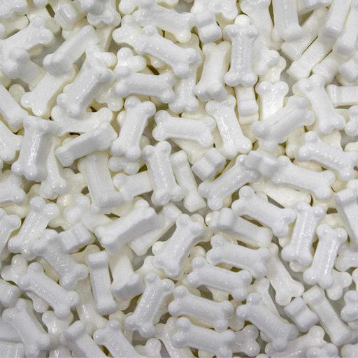 Pile of white, edible, bone-shaped sprinkles for baking and decorating.
