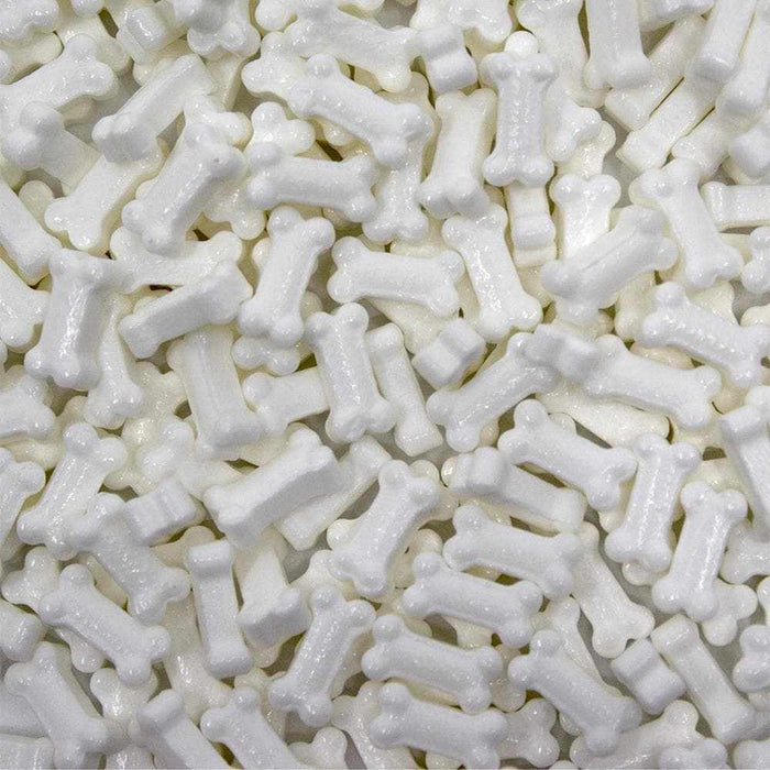 Pile of white, edible, bone-shaped sprinkles for baking and decorating.