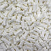 Pile of white, edible, bone-shaped sprinkles for baking and decorating.